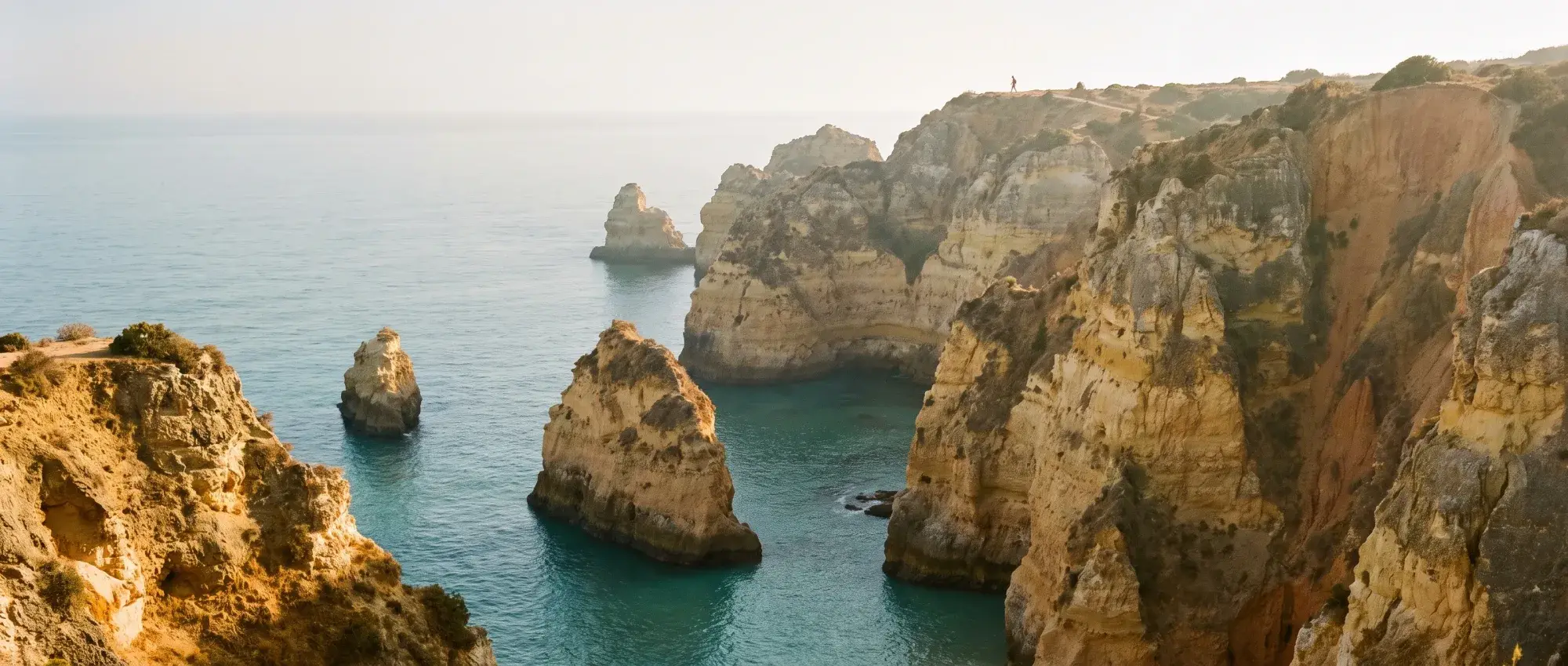 Illustrative image: golden-hour sandstone cliffs and coves on an Atlantic coast